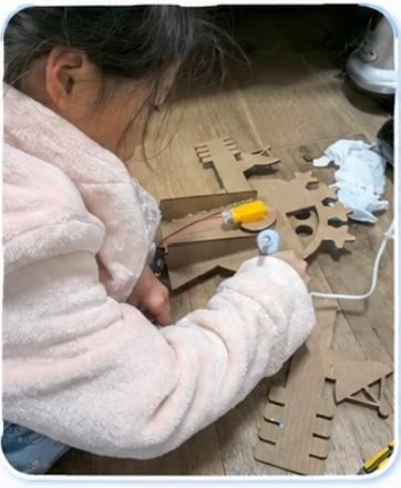 小朋友使用工具固定过山车轨道